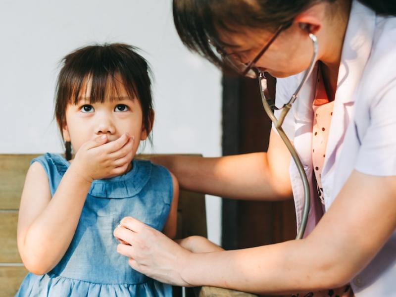 Coughing child checked on by doctor