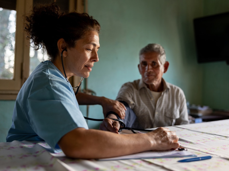 A nurse checks a man's blood pressure 