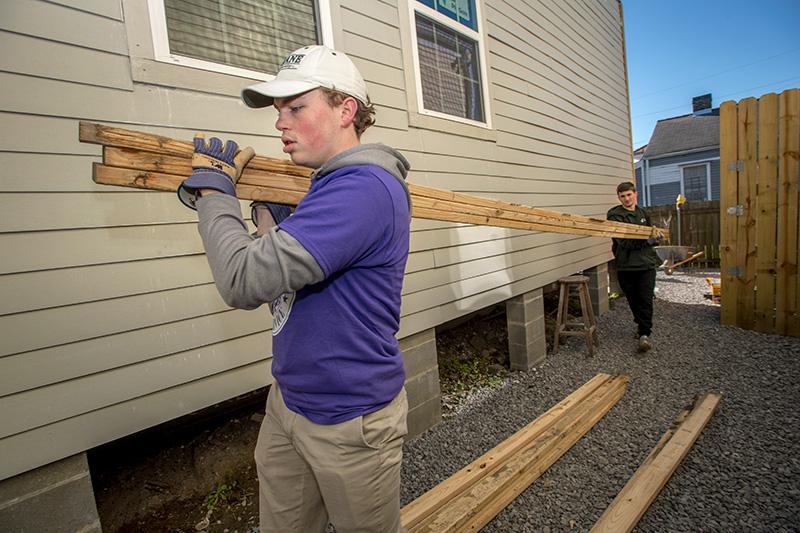 Owen Scher, left, and Tyler Cobelin, both first year students at Tulane, carry two-by-fours to be cut to size in the alley betweens houses in Mid-City. The pair volunteered with Youth Rebuilding New Orleans, a non-profit volunteer organization, formed fol Students volunteer for MLK Day of Service.