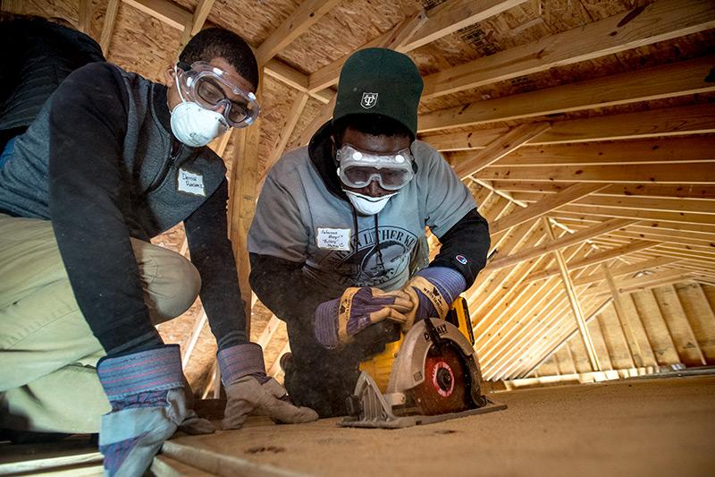 In the attic of a house in Mid-City, Derrick Ransom, left, a junior at Loyola, holds still a sheet of plywood as Tulane senior Anfernee Murray, right, cuts it to fit into place during the annual Martin Luther King, II Day of Service. Students volunteer for MLK Day of Service.