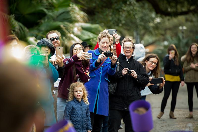 Delighted family members line up to document the procession. The spirit of Mardi Gras was in the air as the Krewe of Newcomb rolled through the uptown campus on Friday afternoon.