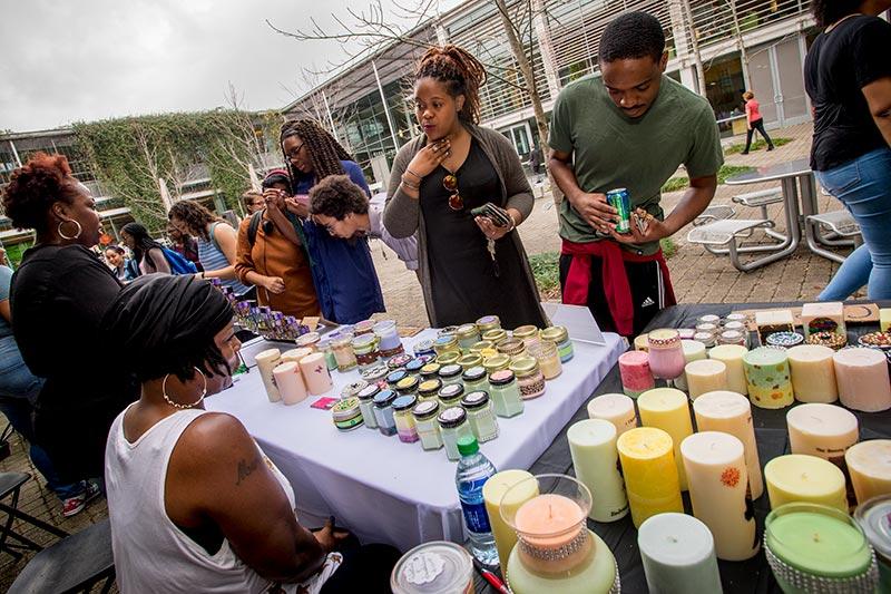 A crowd gathers to purchase scented candles and oils from Ernestine Wright, far left, and her sister Almalita Wright, left. Black Art Market turns Pocket Park into a festive bazaar.