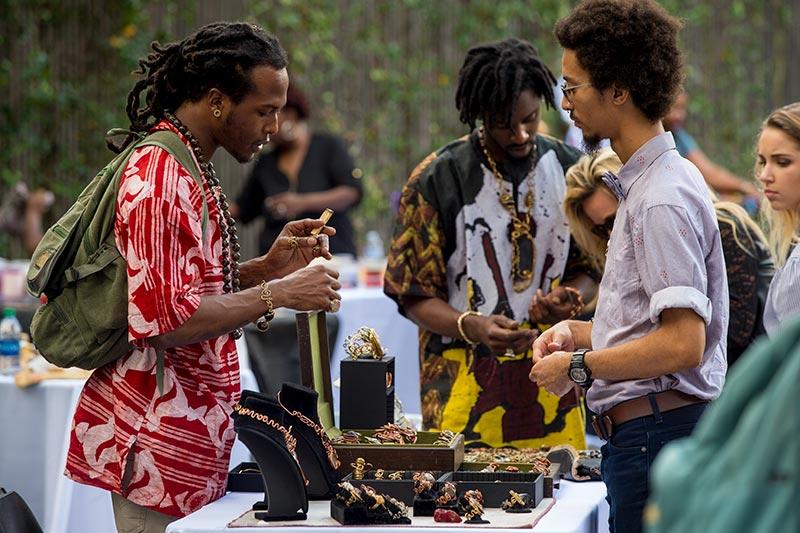 Ashlin Washington, left, and jeweler Jordan Lewis, center, field questions from customers. Black Art Market turns Pocket Park into a festive bazaar.