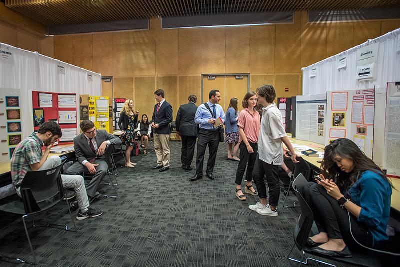 Students hang out near their projects while anticipating questions from judges. Young scientists converge on the uptown campus for annual science and engineering competition.