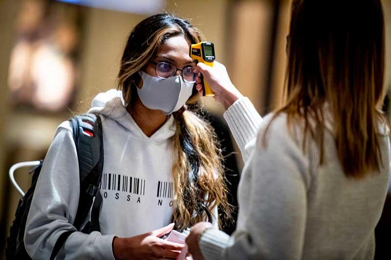 Shreya Srigiri gets her temperature checked as she enters the Arrival Center