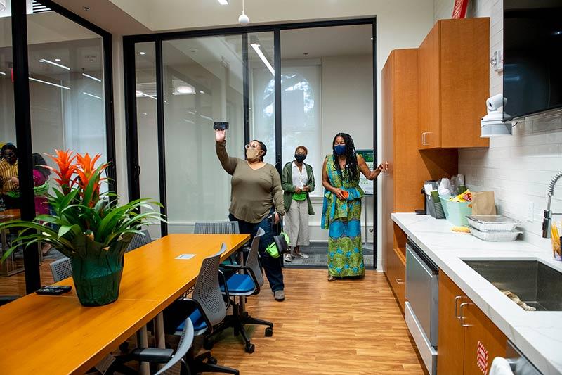 Carolyn Barber-Pierre (right), assistant vice president for student affairs and intercultural life, shows off the sleek new kitchen, one of the highlights of the new building. 