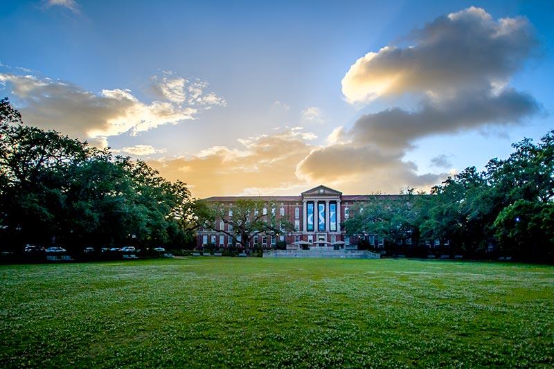 The setting sun highlights the architectural beauty of Newcomb Hall.