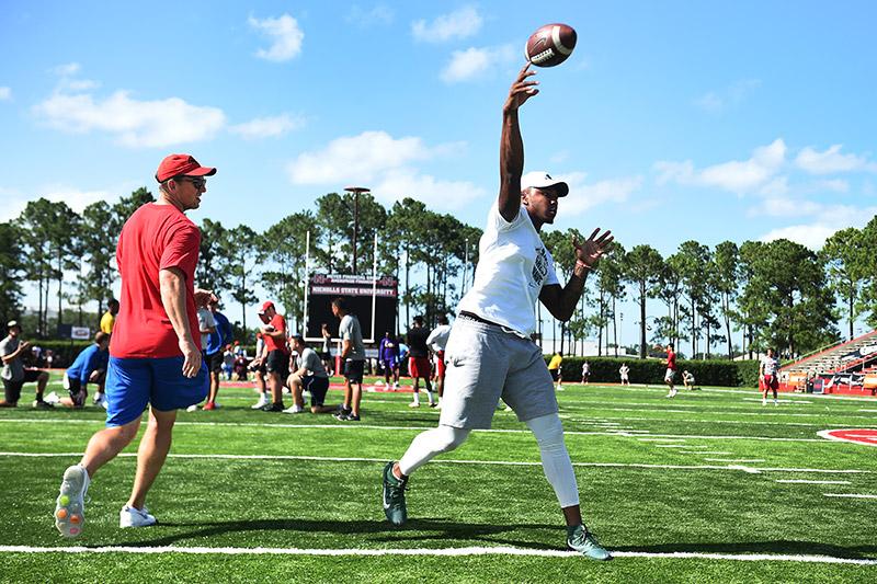 Green Wave senior quarterback Jonathan Banks throws a pass while New York Giants quarterback and New Orleans native Eli Manning, left, studies his form at the 2018 Manning Passing Academy football camp on the Nicholls State University campus in Thibodaux, Green Wave football players get one-on-one instruction from Manning brothers during annual football camp.