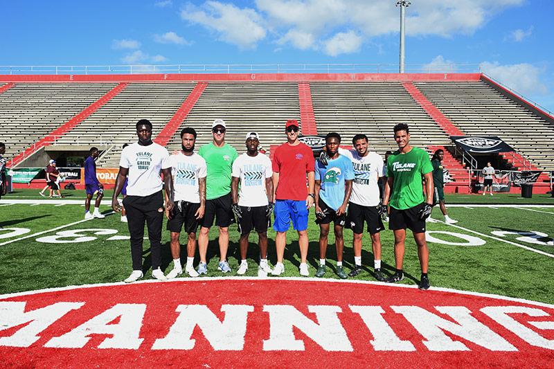 Green Wave football players get one-on-one instruction from Manning brothers during annual football camp.