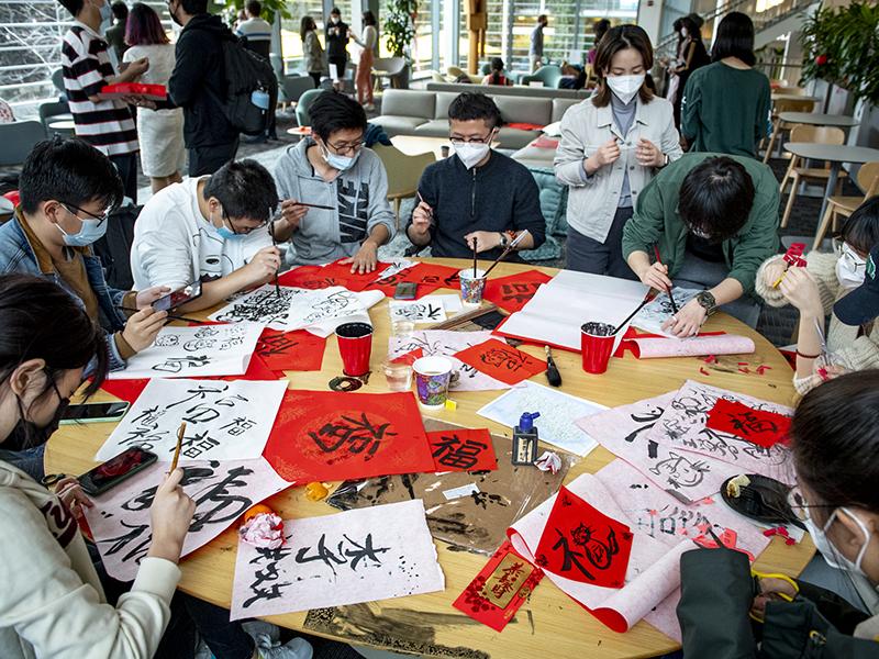 Students practice Chinese calligraphy. 