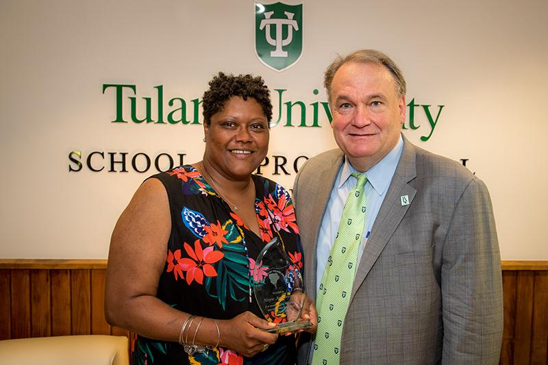 Holding her award, Hope Anderson, Operations Assistant in the School of Professional Advancement, left, poses with President Fitts. President Fitts surprises outstanding employees with special delivery.