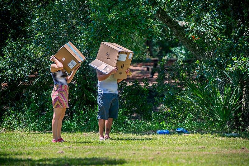 Two sun-gazers got creative using cardboard boxes to view the eclipse. Locals are captivated by the awe-inspiring solar eclipse.