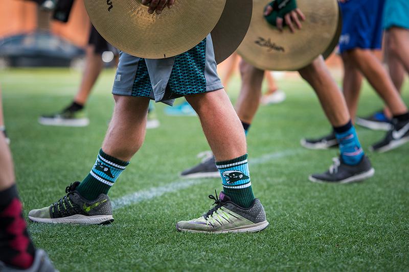 A member of the cymbal section sports a pair of Angry Wave crew socks. The Tulane University Marching Band (TUMB) braves the August heat and humidity to practice marching basics during the annual band camp on Brown Field.