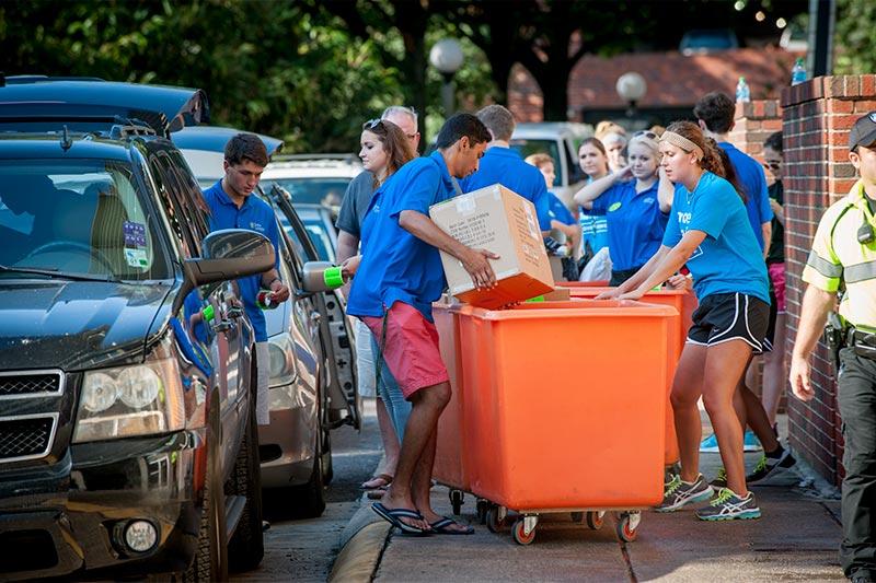 Members of the Move Krewe load students’ belongings into portable orange containers. A successful move-in is a well choreographed dance with boxes, bins and books.