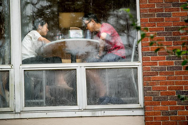 Oblivious to the weather outside, Hongyi Chen, left, and Weihao Shen, graduate students in the master of finance program, share a meal and conversation in Bruff Commons. Members of the Tulane community took advantage of a day off Tuesday due to possible heavy rain and flooding from Harvey.