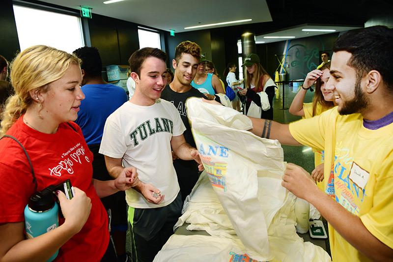 David Aspillaga, right, hands out official 2018 Outreach t-shirts to first-year students Eliza Inder, Luke Pertuit and Ryan Keit-Weerakoon, left to right. Students participate in the 28th annual Outreach Tulane.