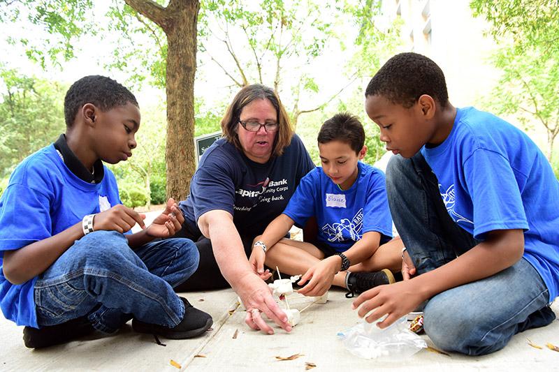 A teacher advises students on constructing a marshmallow catapult to see how far they can catapult a penny. Curiosity + fun = knowledge during the fall 2018 Boys At Tulane in STEM event.