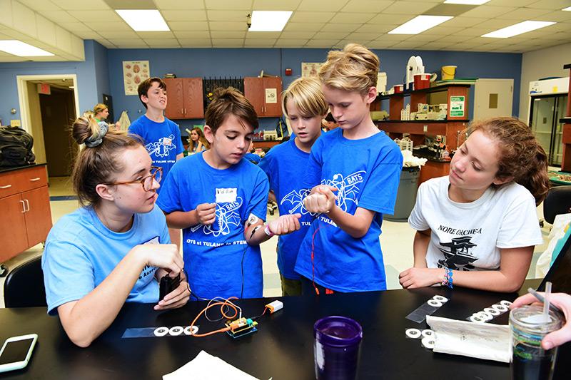 Tulane University Neuroscience Association (TUNA) members Sarah McLenan, left, and Anna Testore, right, host a workshop about the central nervous system. Curiosity + fun = knowledge during the fall 2018 Boys At Tulane in STEM event.