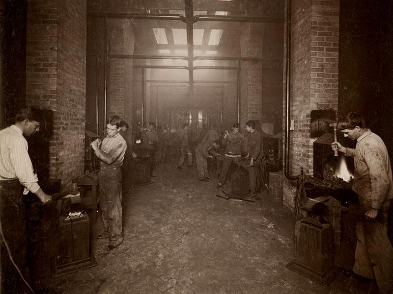 Engineering students work in the blacksmith shop laboratory of the mechanic arts program in the Tulane University College of Technology, around the turn of the century.