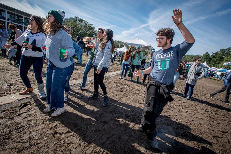 Tulane senior Mason Pearcy, right, gets his groove on while listening to the sounds of the Time of Your Life Band from Atlanta. Homecoming brings together families, alumni