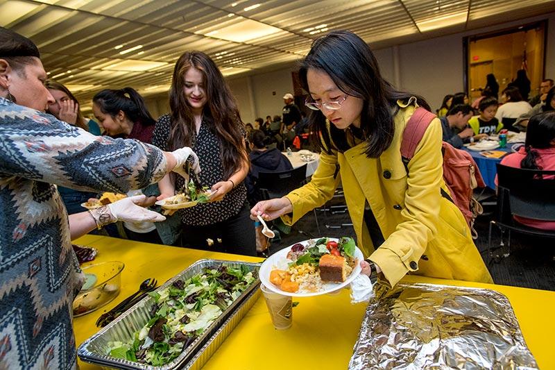 Abigail Rodriguez’s plate is topped off with a green salad while Susan Chou, right, helps herself to the dressing at the annual Pot Luck Thanksgiving Dinner on Tuesday evening (Nov. 22) in the Qatar Ballroom. The 2016 Pot Luck Thanksgiving Dinner featured food, fun and fellowship.