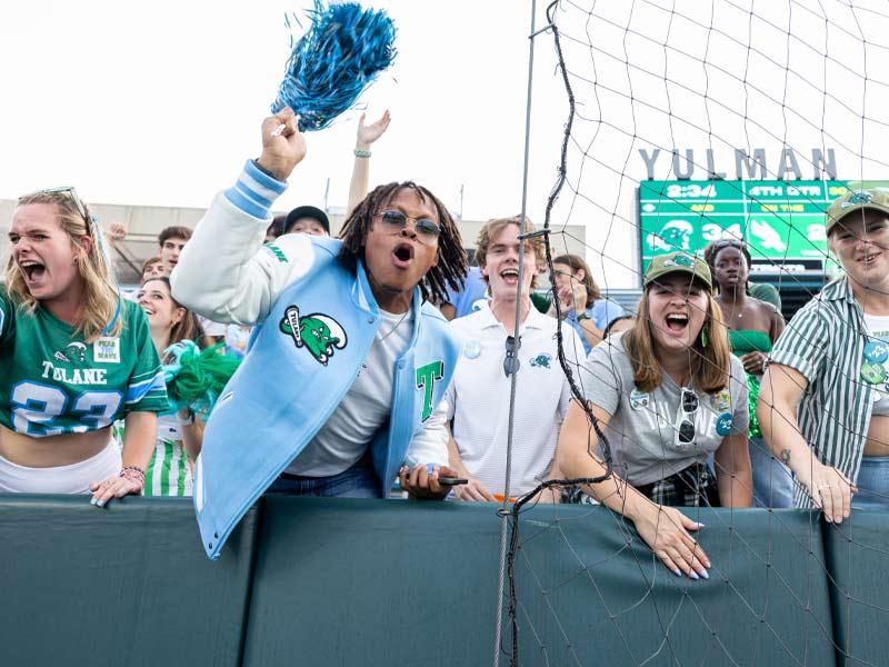 Donning their Tulane gear, Tulanians cheer on the Green Wave with excitement.
