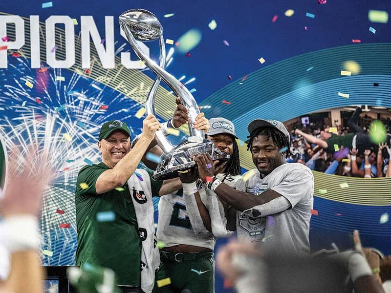 Tulane football team members celebrating with the Cotton Bowl trophy