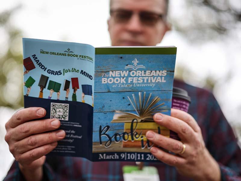 An attendee holding a Book Festival program at the 2023 festival 