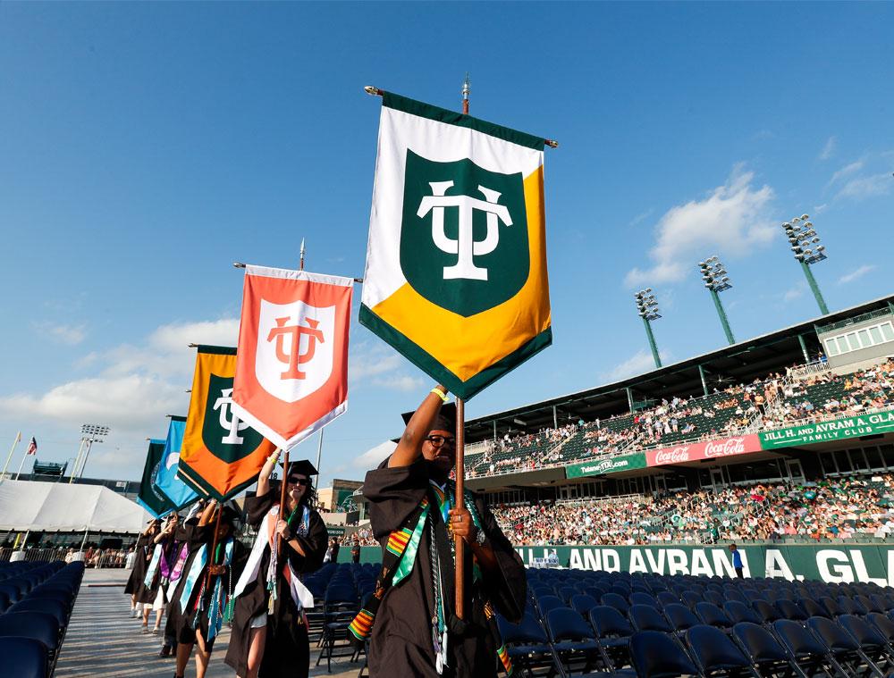 Graduates carrying the university’s ceremonial gonfalons, which represent Tulane’s schools and colleges, kick off the procession. (Photo by Tyler Kaufman)
