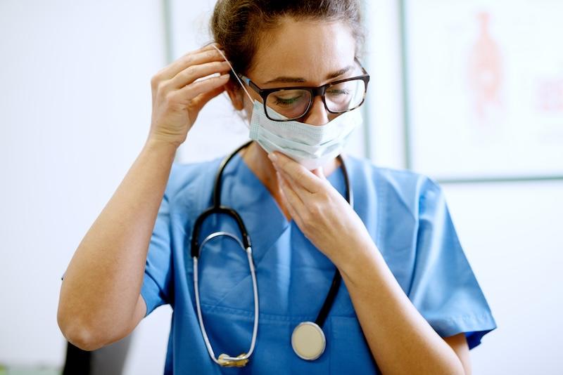 A nurse puts on a mask