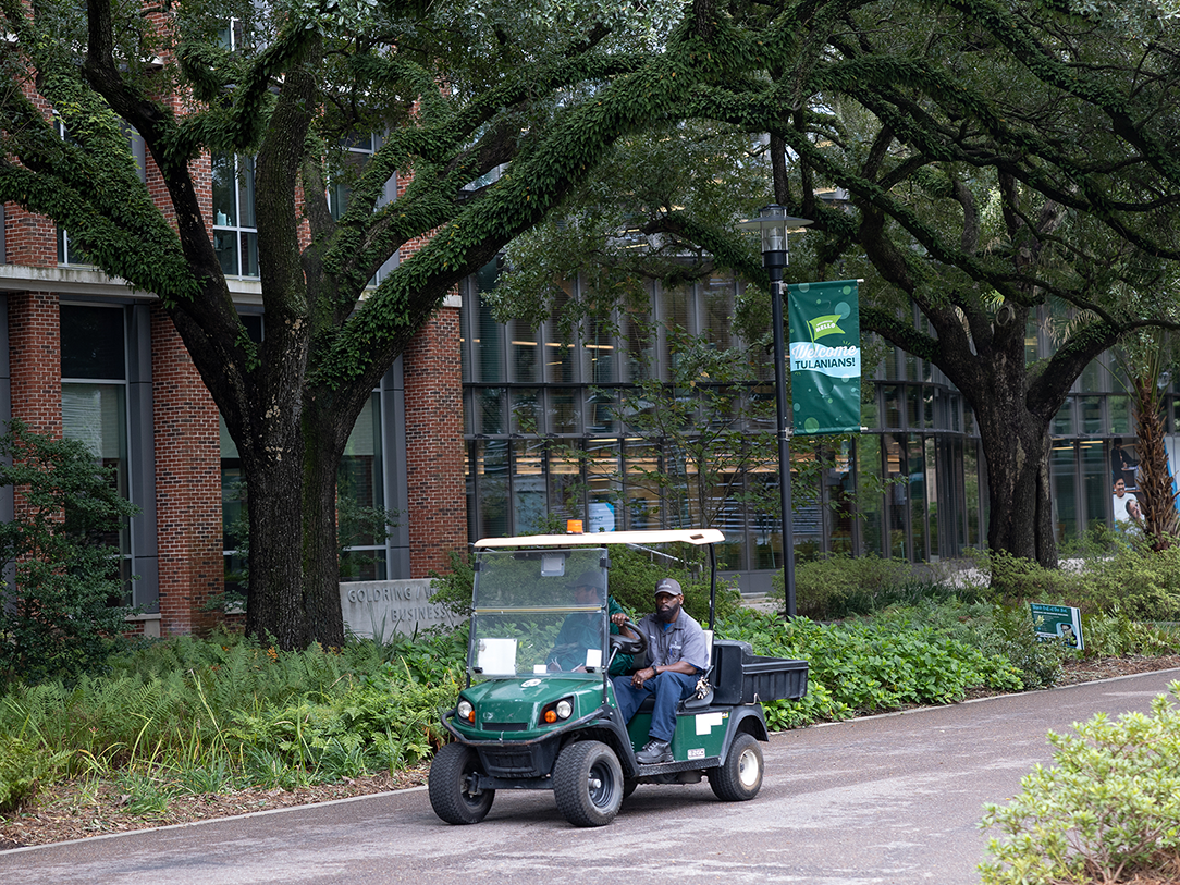 A golf cart in front of the Goldring/Woldenberg Business Complex