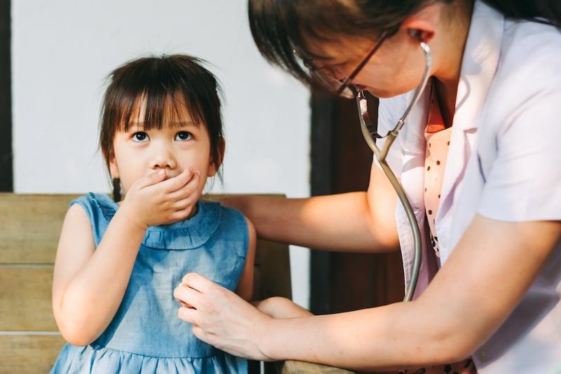 Coughing child checked on by doctor