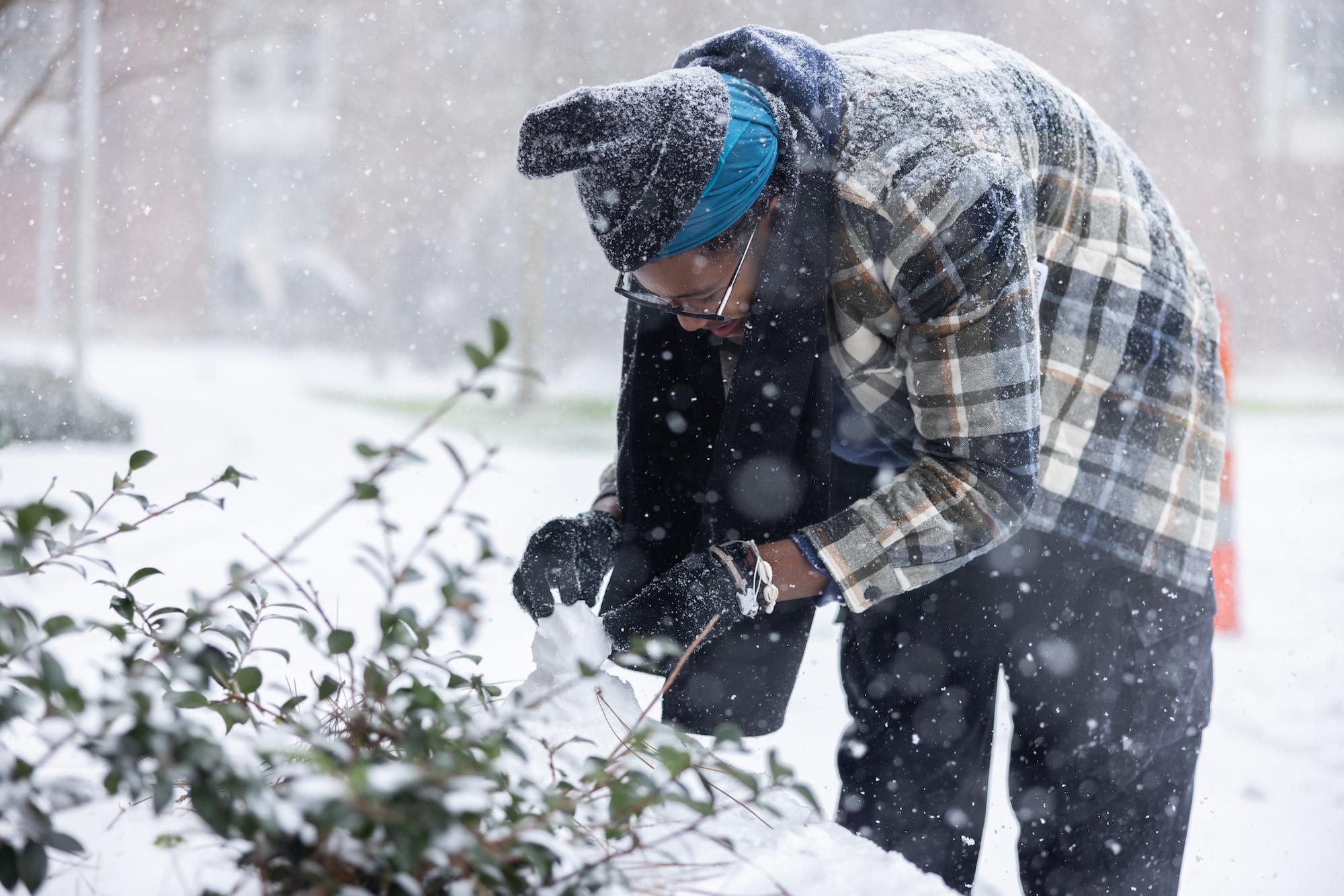 A student builds a snowman 