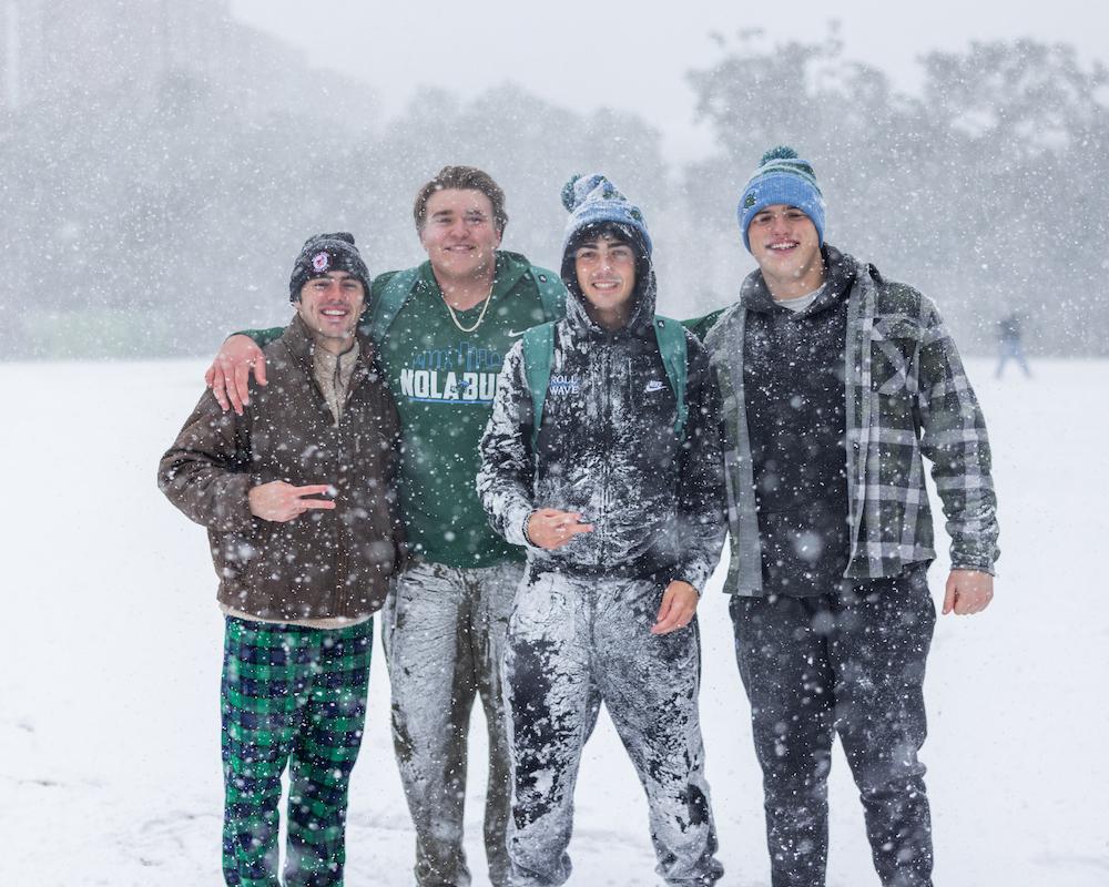 Four students posing in the snow 