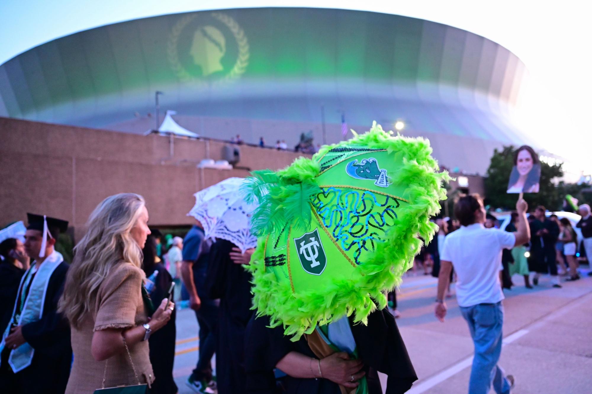 A grad with a decorated umbrella outside the Superdome