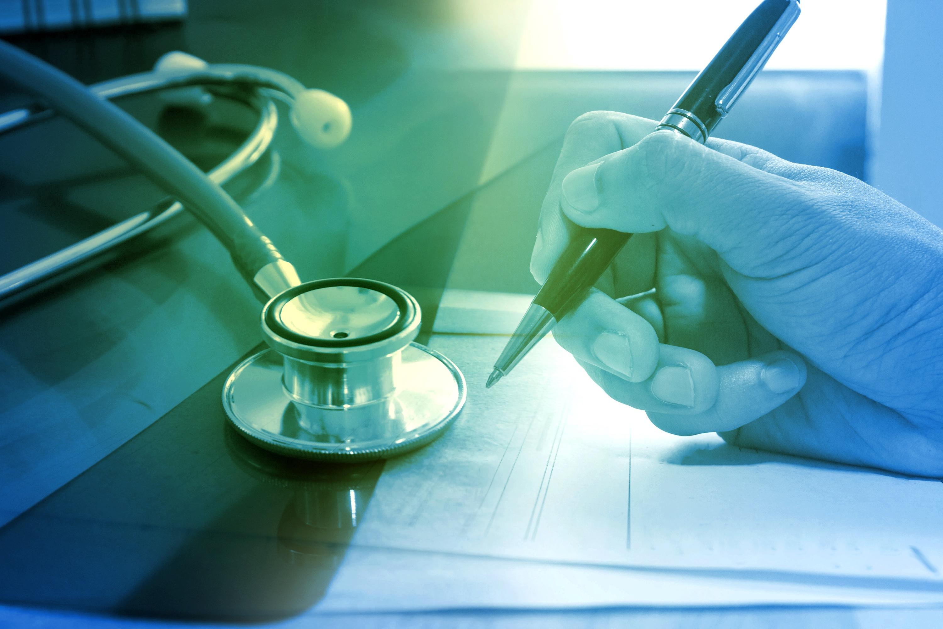 Doctor writing notes with stethoscope