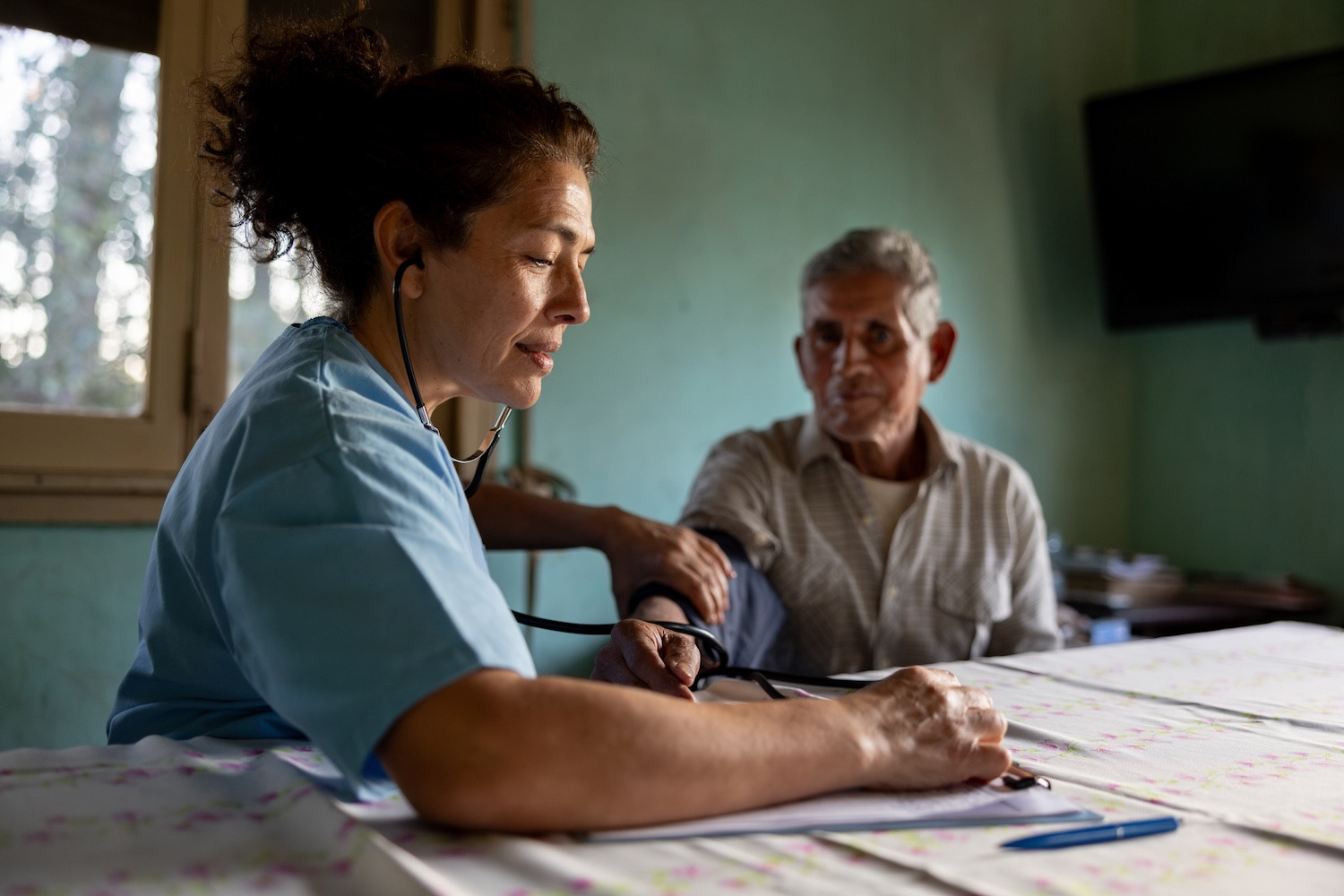 A nurse checks a man's blood pressure 