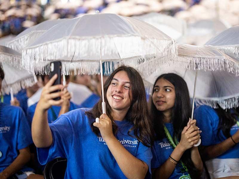 Students take a selfie while holding their new Convocation umbrellas. Students are encouraged to adorn the umbrellas with memorabilia during their time at Tulane. 