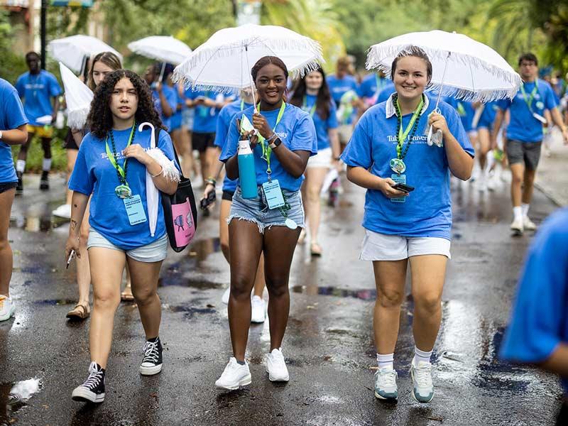 New students walk down McAlister Way with their Convocation umbrellas in tow. 