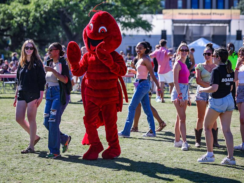 Carl, the Crawfest mascot, mingles with the crowd on the Berger Family Lawn.