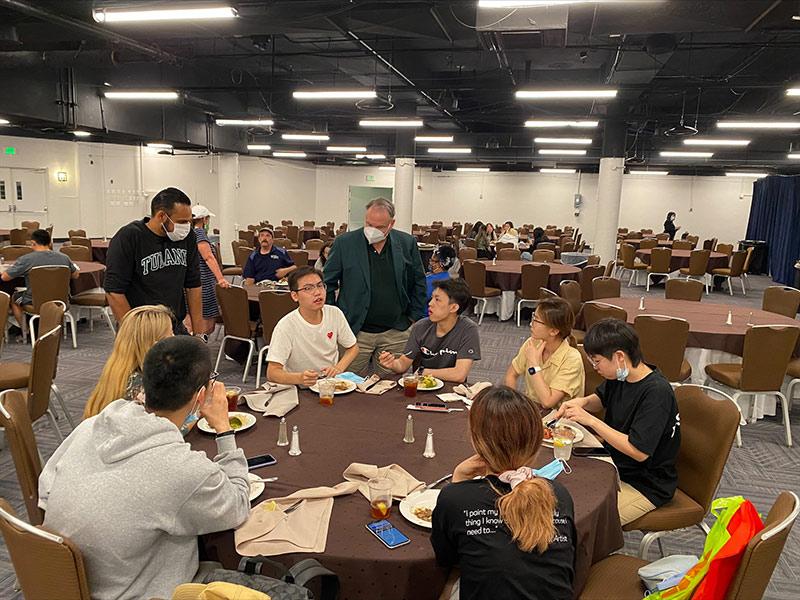 Satya Dattagupta (left), senior vice president and dean of admission for enrollment management and graduate and pre-college strategy, and President Michael Fitts (right) talk with students at the Houston hub. (Photo by Katie Acuff)