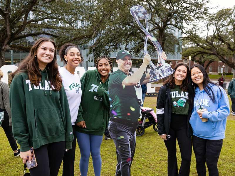 Fans pose with a cutout of Coach Fritz holding the Cotton Bowl trophy. 