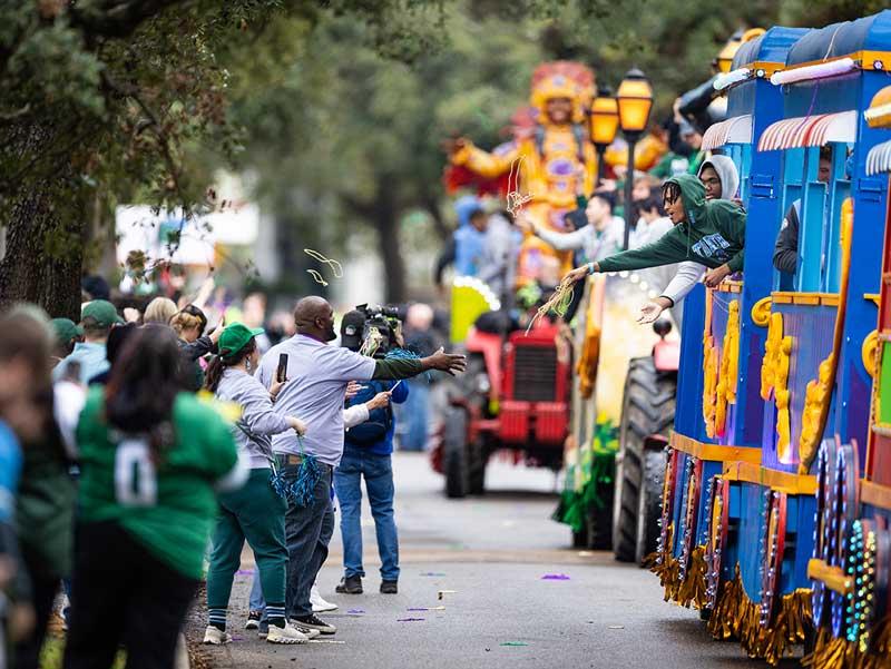 The Green Wave football parades through the uptown campus on colorful floats. 
