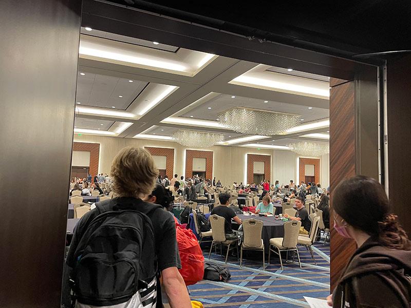 Students sit in the hotel ballroom to eat, make phone calls and get settled after traveling. 