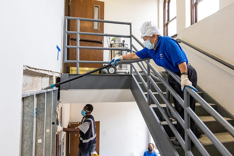 Contract workers and employees of MRB Contractors remove dry wall in the Norman Mayer Building. 