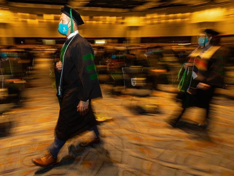 Candidates process to the stage to be bestowed their Doctor of Medicine degrees.