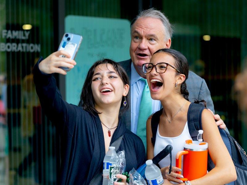 President Michael A. Fitts with two students