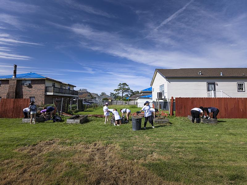 Students help clean up at Bethany United Methodist Church. Damage to the fence and surrounding roofs can be seen from Hurricane Ida. 