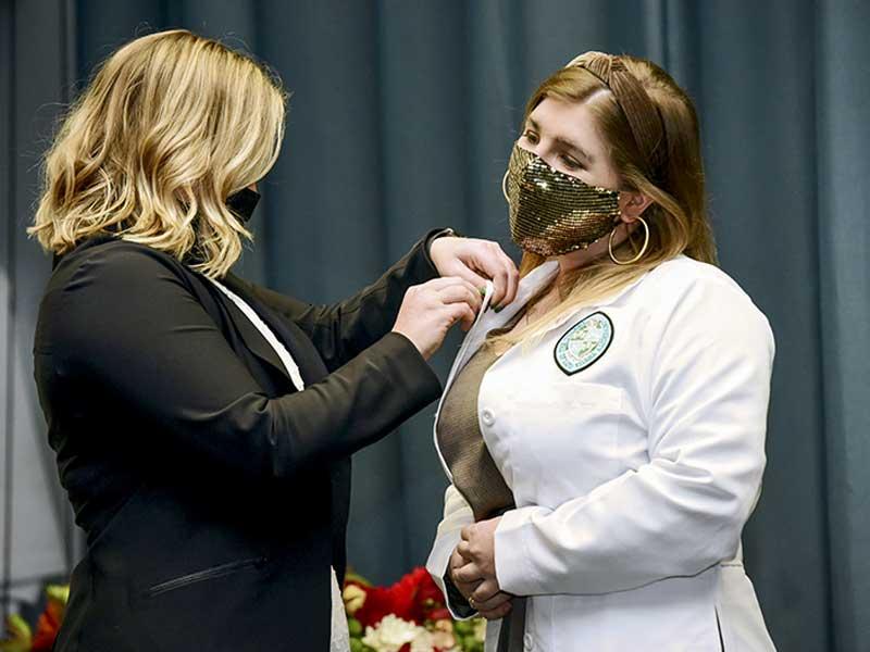 Jillian Aveni receives pin from program director Sarah Garner