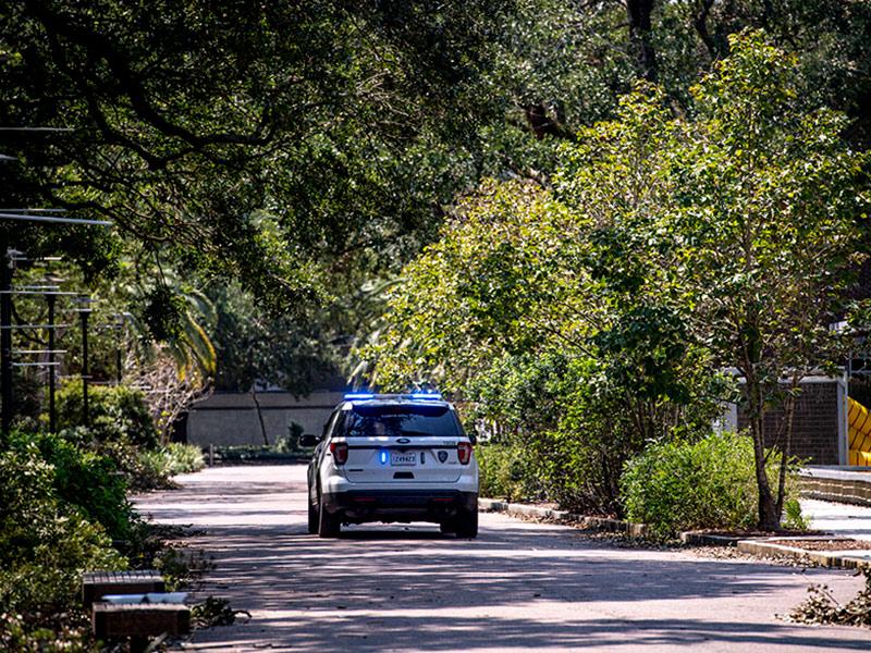 A Tulane University Police Department unit blocks the roadway on campus as the campus remains open only to essential personnel. 